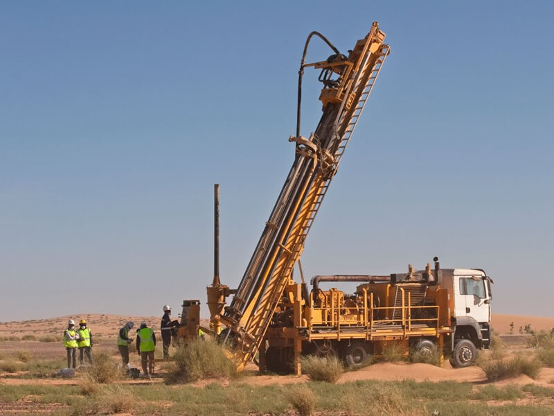 individuals operating large drilling truck
