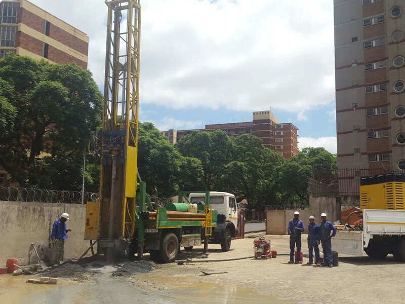 drilling truck next to apartment buildings