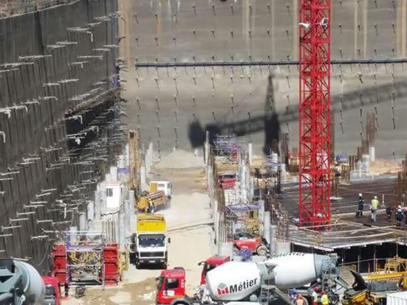 construction yard with vehicles and red crane